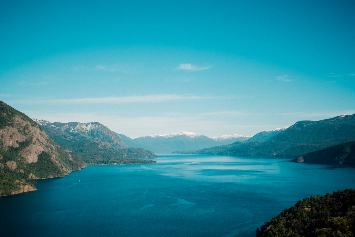 A long blue lake between forested mountains near San Martín de los Andes, with snow on the far peaks