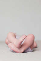 Baby feet in neutral-toned Hoko shoes resting gently on a soft white rug.