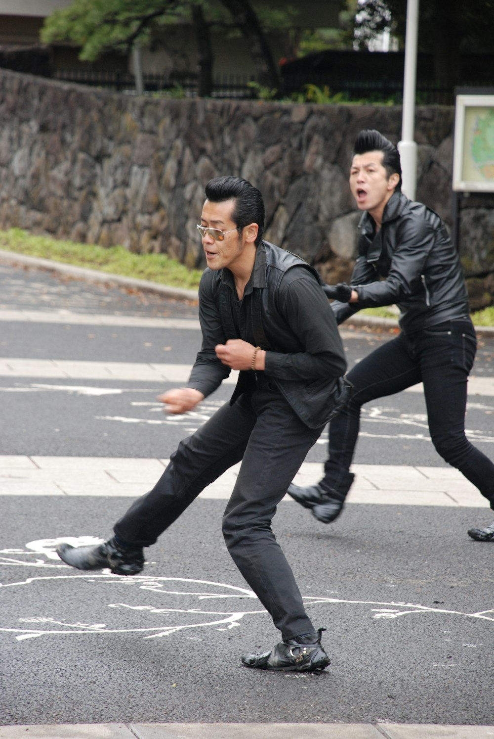 selective focus photography of man dancing on concrete road during daytime