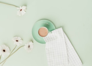 cup of beverage with daisies