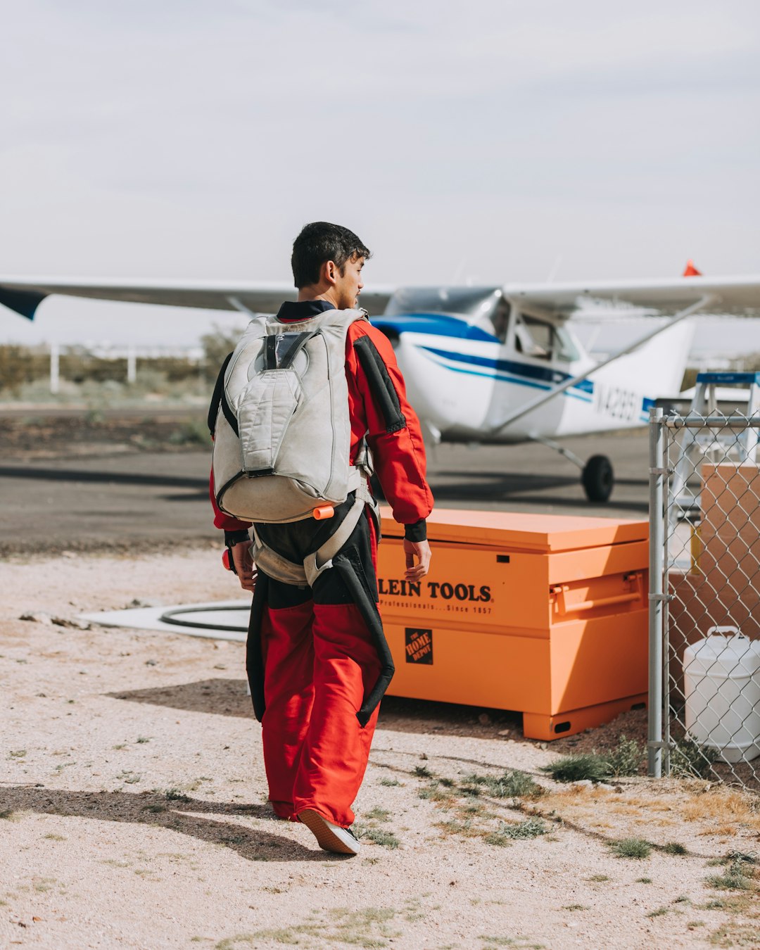 man carrying backpack wearing red coveralls