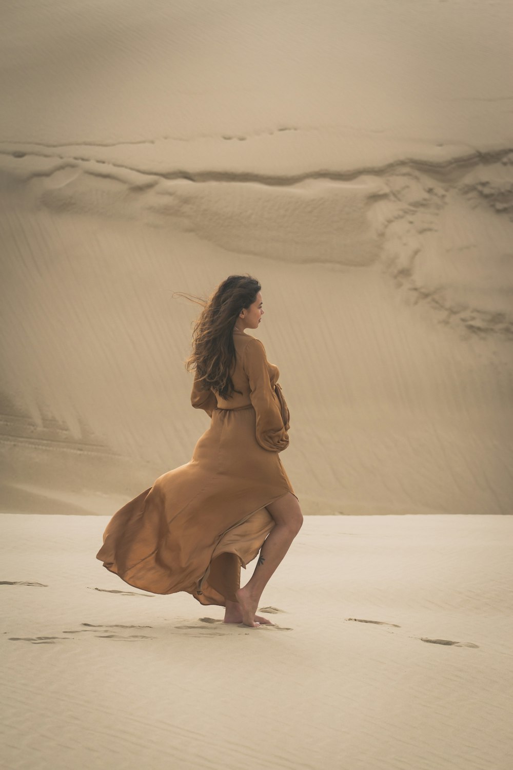 woman walking on sand during day