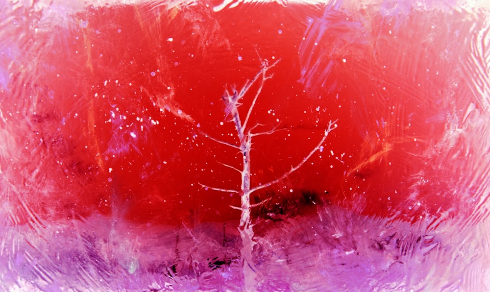 Una pintura de un árbol con colores rojo y púrpura