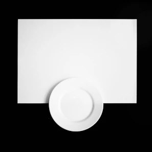 Close-up of a sturdy white cardboard plate on a clean white background.