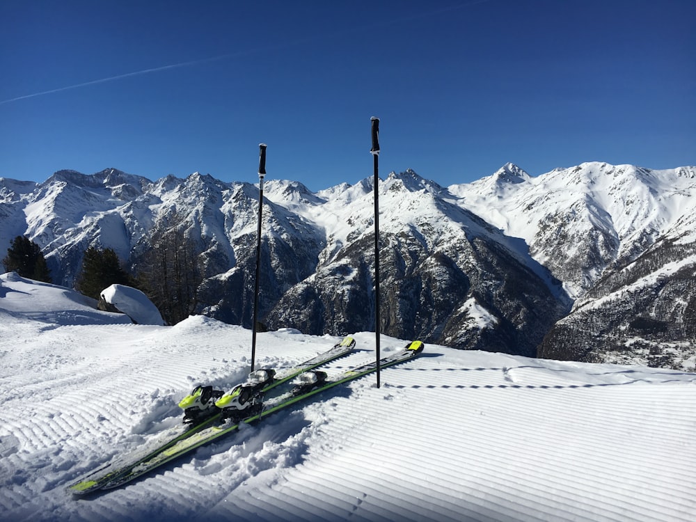 Lâminas de esqui verdes na montanha de neve