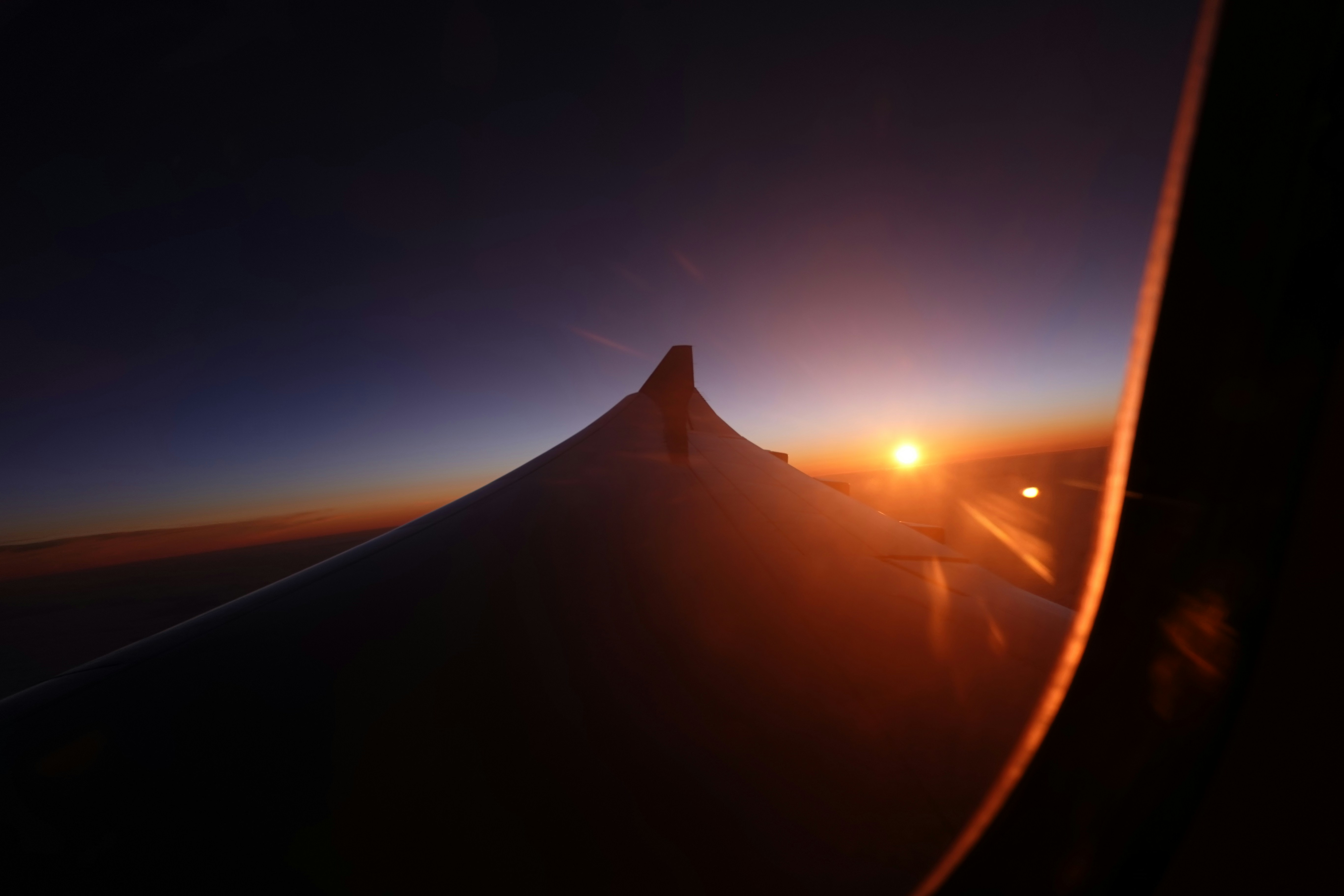 Vue de fenêtre de l’aile d’avion pendant l’heure dorée