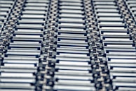 Overhead view of metal sheets arranged methodically on industrial rollers, ready for fabrication.