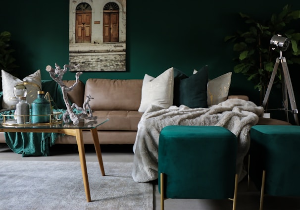 Spacious, stylish living room featuring plush beige sofas and dark green accents