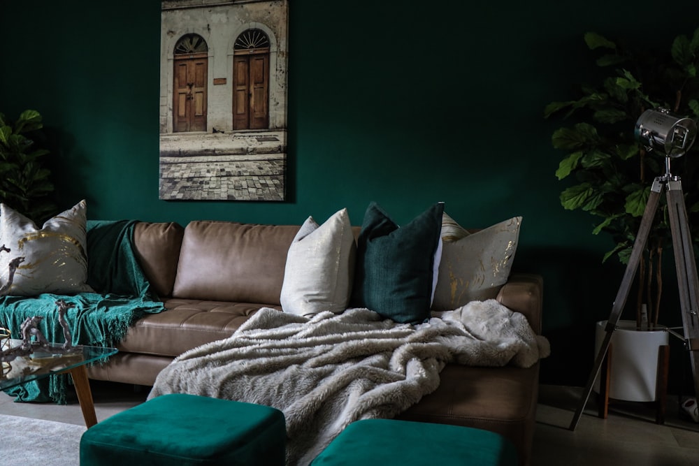 sofá acolchoado de couro marrom com travesseiros dentro de casa