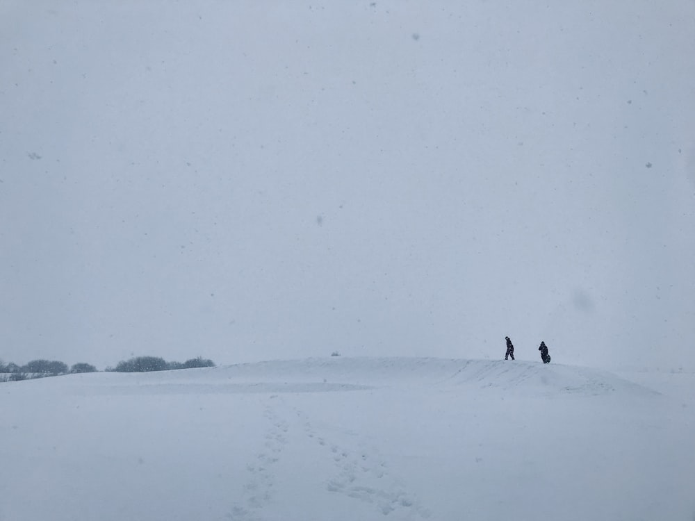 Silhouette von zwei Menschen auf verschneitem Land