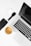 A well-arranged flat lay of modern tech gadgets placed on a white surface, including a sleek black smartphone, wireless earbuds in a white case, a black smartwatch, a silver laptop with a black keyboard, and a cup of coffee with a rich crema.