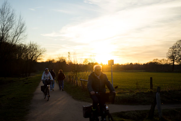 Cyclists riding along a scenic rural path during the pilgrimage at sunrise.