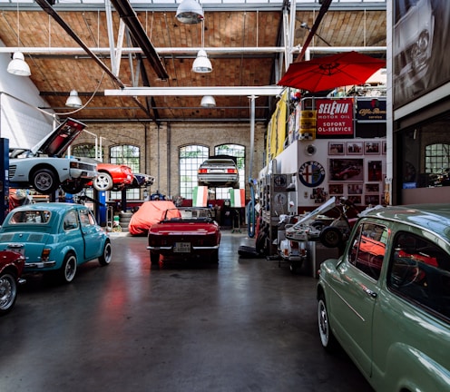 Inside auto shop several cars, parked along the wall