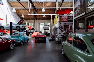 Inside auto shop several cars, parked along the wall