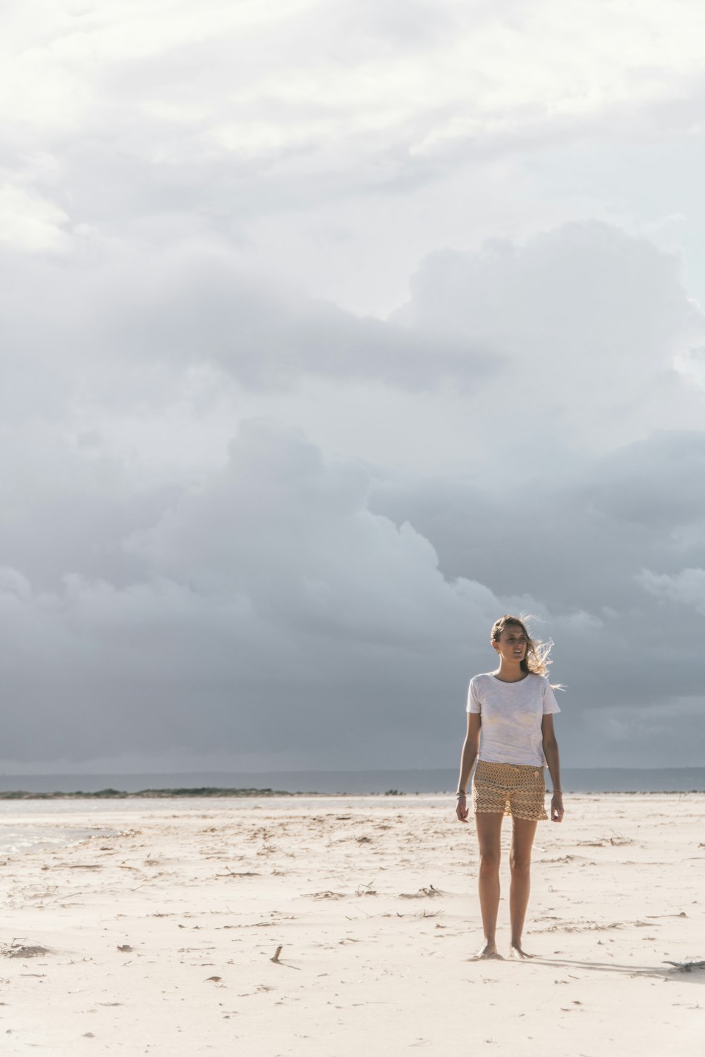 mujer de pie en la orilla del mar