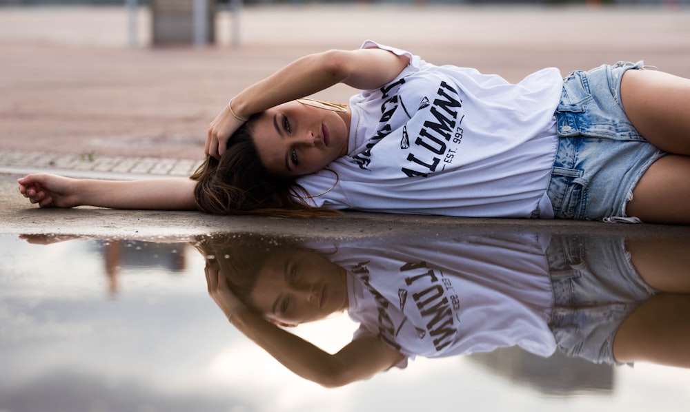 woman lying on ground near puddle