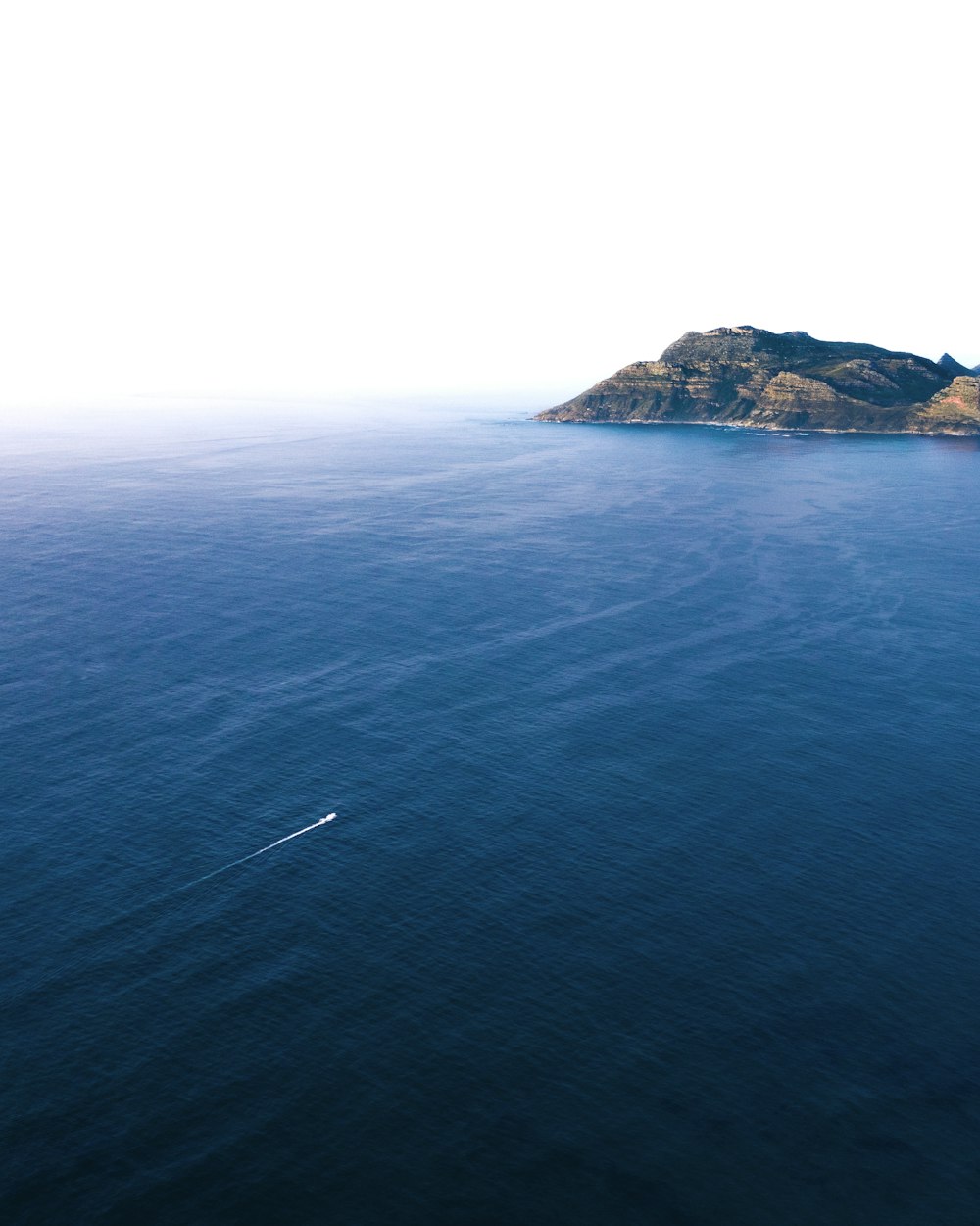 sea near the mountain during daytime