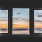 white wooden framed glass window near body of water