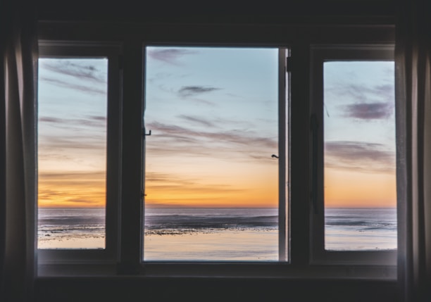 white wooden framed glass window near body of water