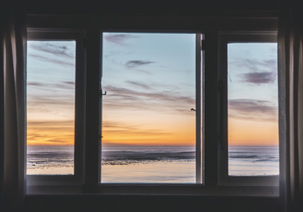 white wooden framed glass window near body of water