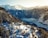 A picturesque winter landscape featuring snow-covered mountains and a serene valley. Cozy wooden chalets are scattered on a forested slope, surrounded by snow-laden trees. The sun casts a warm glow, highlighting the beauty of the landscape.