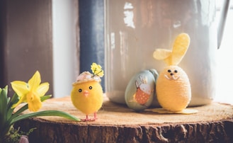 yellow bird plush toy on brown wood