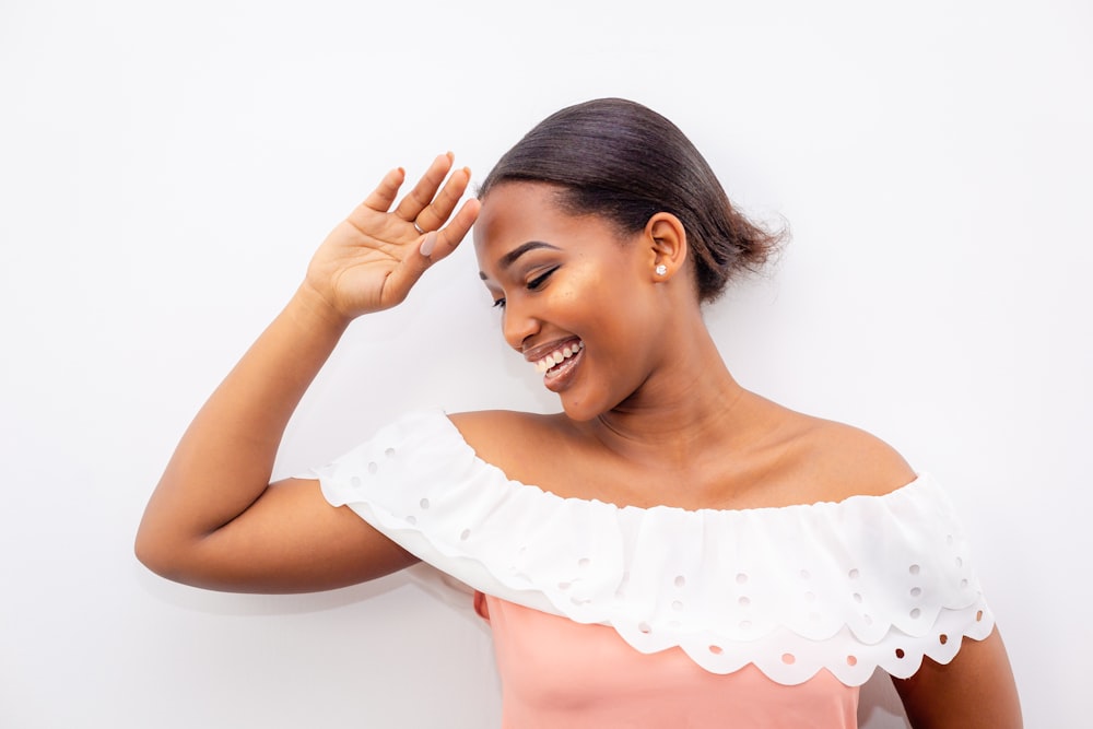 smiling woman wearing white and pink off-shoulder dress