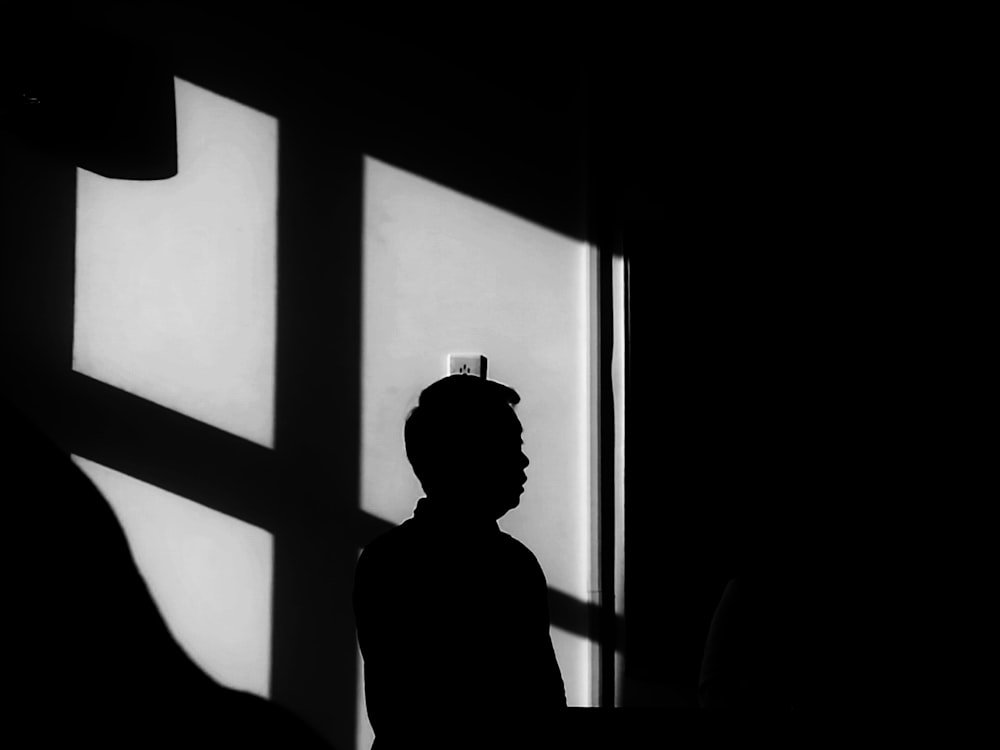 silhouette of person across wall switch