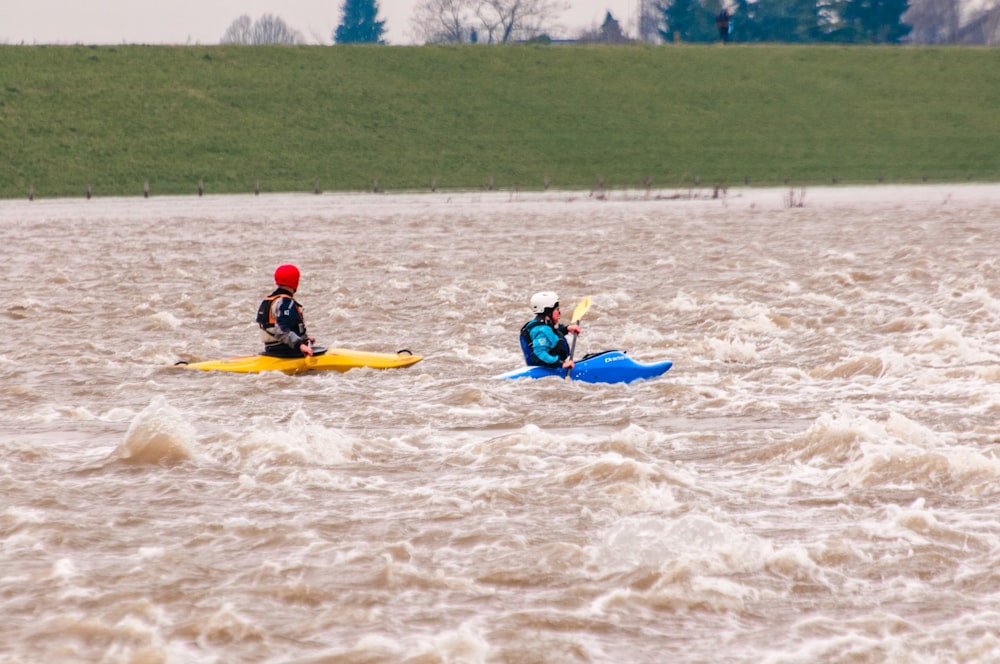 2 person riding yellow kayak on water during daytime