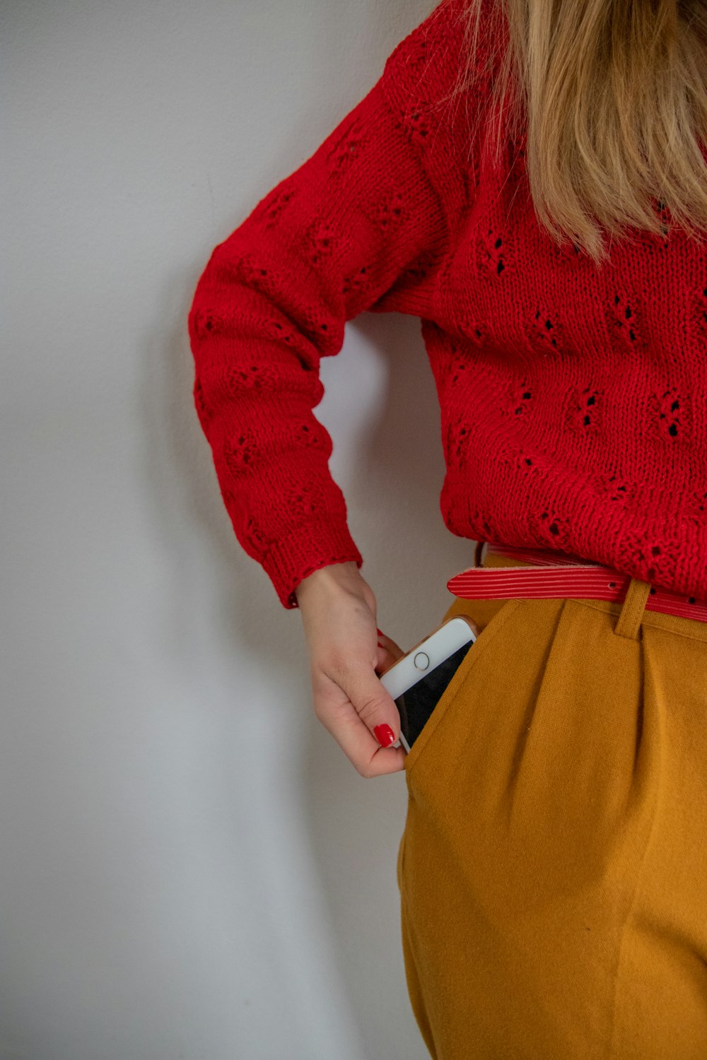 Frau steht und hält ein goldenes iPhone in der Hand