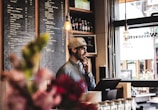 man wearing brown cap in across menu board