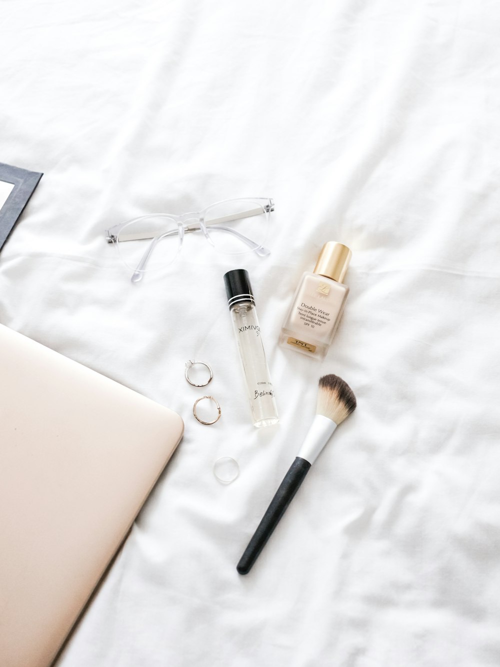 two bottles, one eyeglasses, and one brush on textile