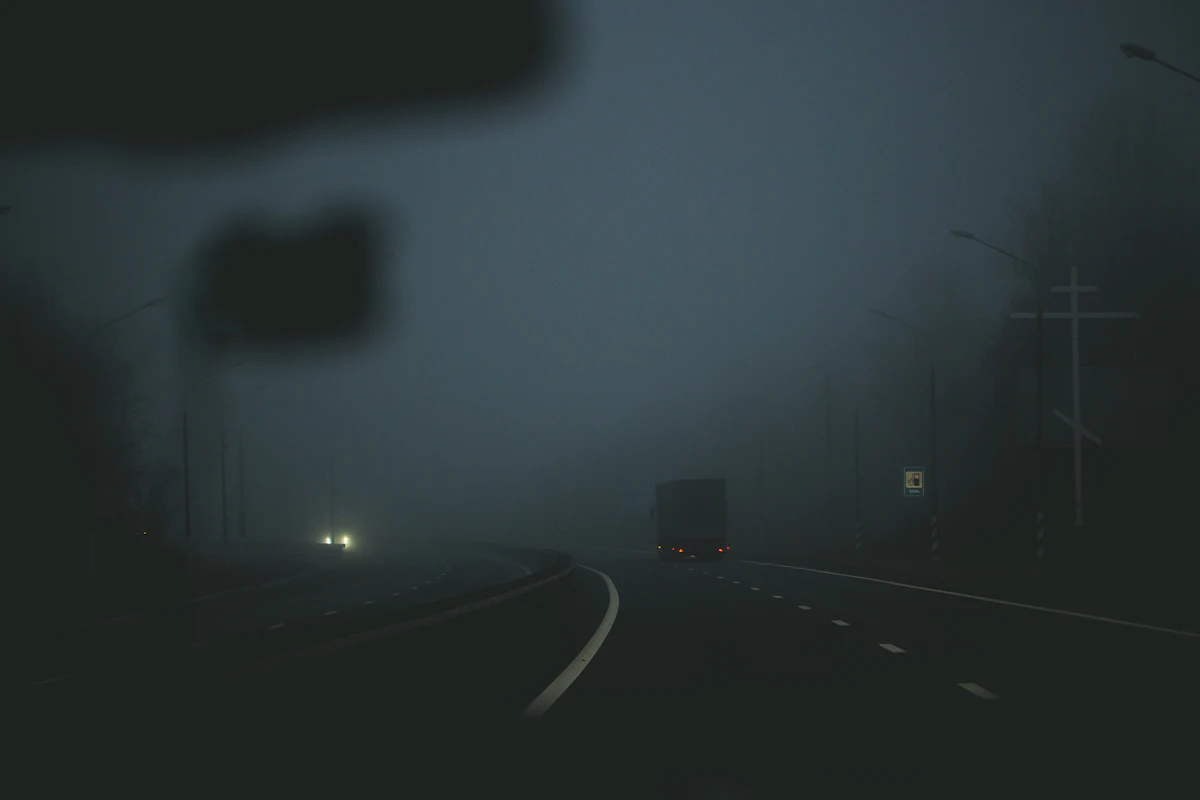 A truck on a foggy highway at night