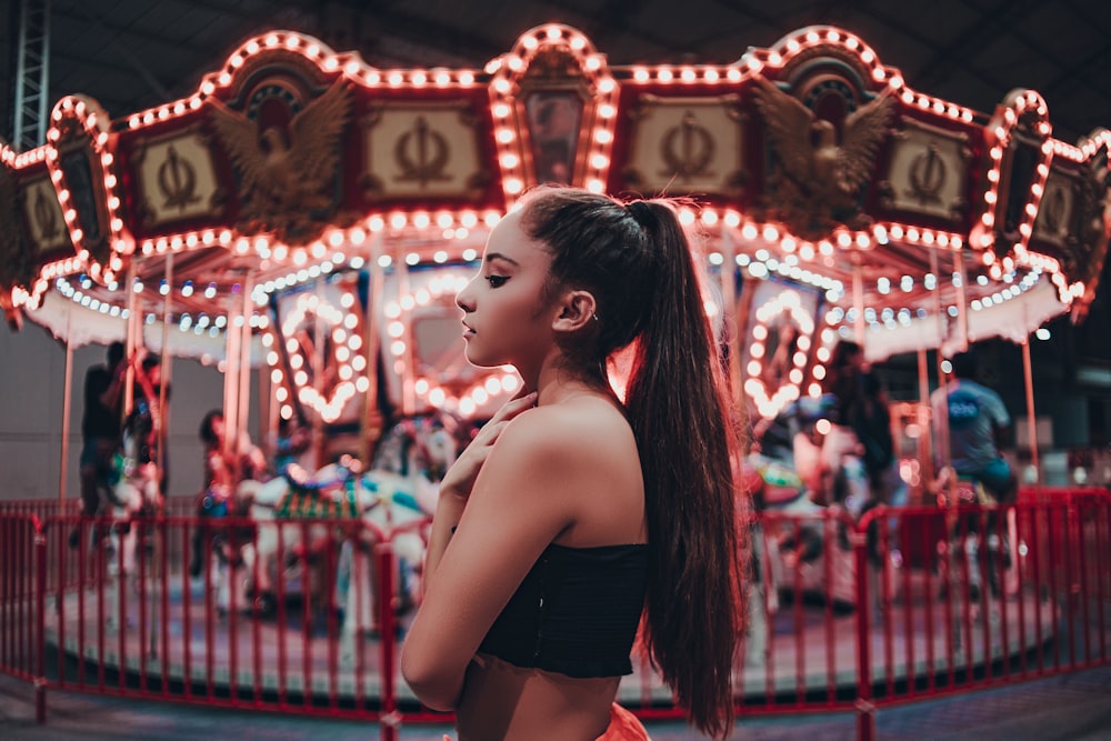 woman standing beside carousel