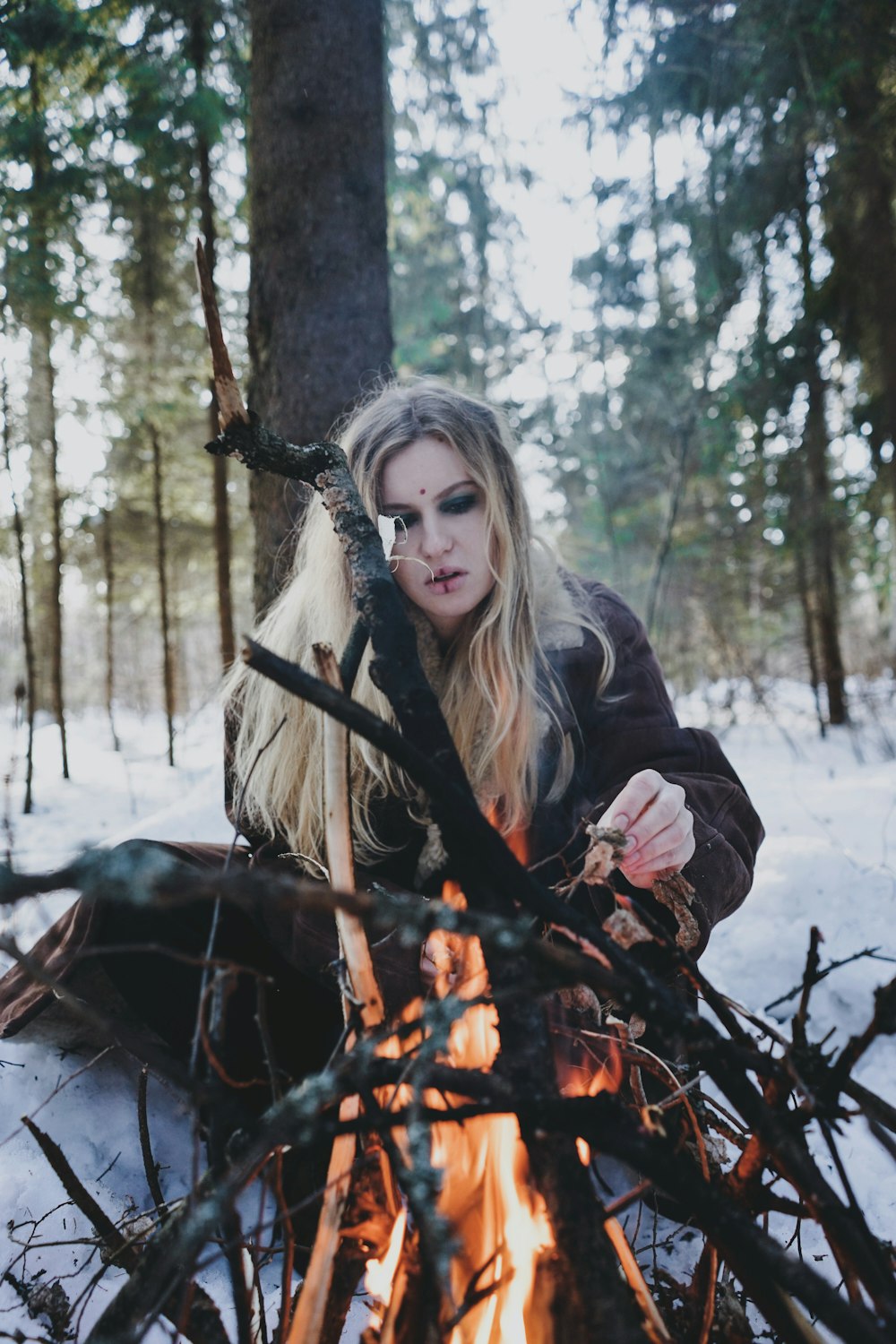 woman sitting in front of burning wood