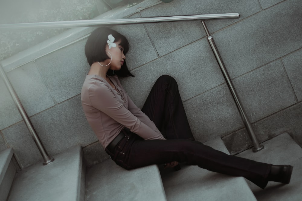 woman sitting on stairs leaning on wall