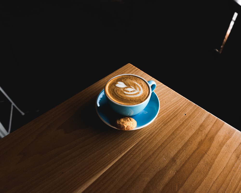 blue ceramic teacup on brown wooden surface