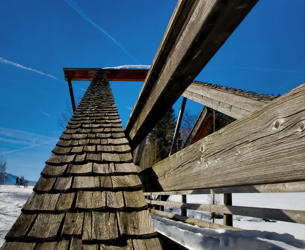 una struttura in legno con neve sul terreno