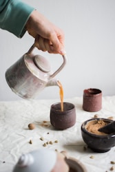 person pouring coffee on brown cup