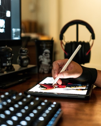 close-up photography of person drawing on tablet computer