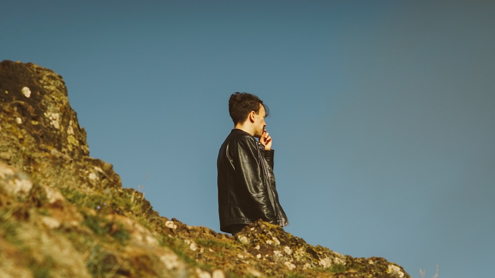 selective focus photography of man standing on mountain