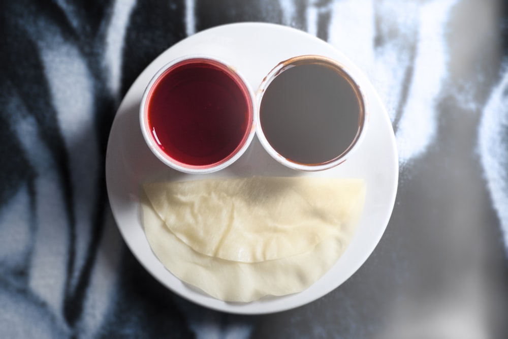 two white ceramic cups on round white ceramic plate