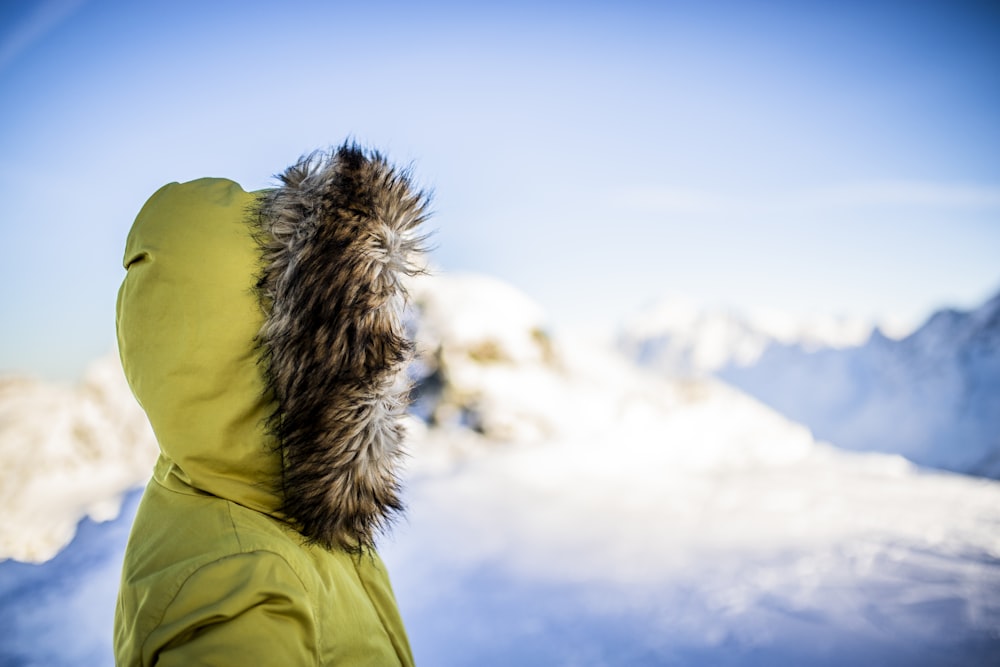 person wearing green and brown parka jacket