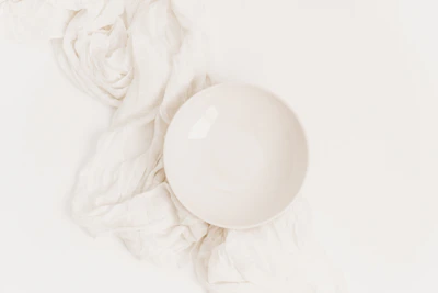 Close-up of a smooth, minimalist white ceramic bowl on a kitchen counter.