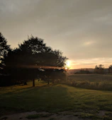 Sunset over Xalapa's lush green hills creating a serene atmosphere.
