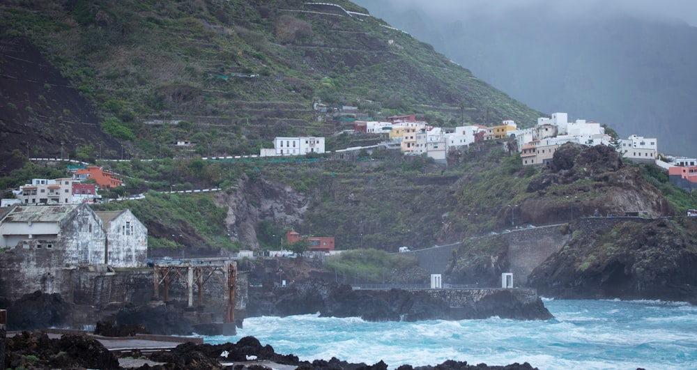 panoramic photography of city near shore at the bottom of the mountain