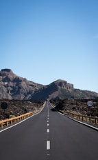 straight asphalt road with mountain background