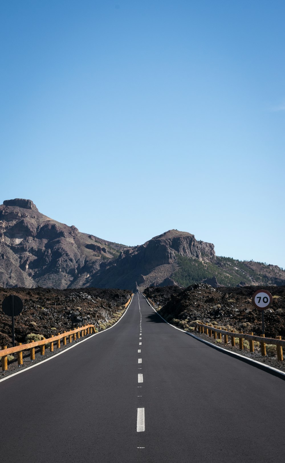 Carretera recta de asfalto con fondo de montaña