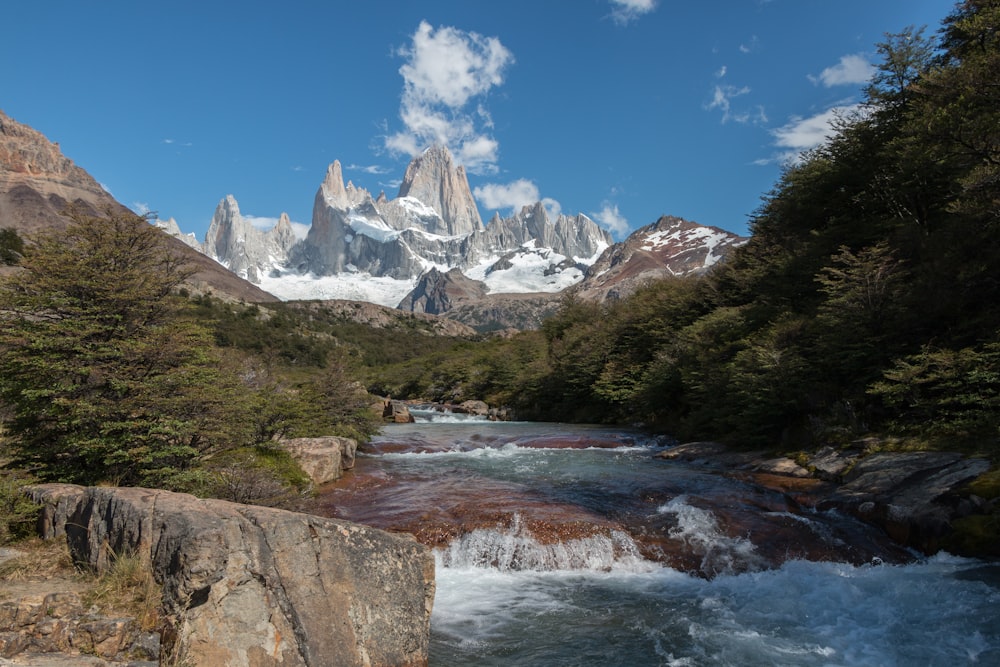 river near mountain covered by snow