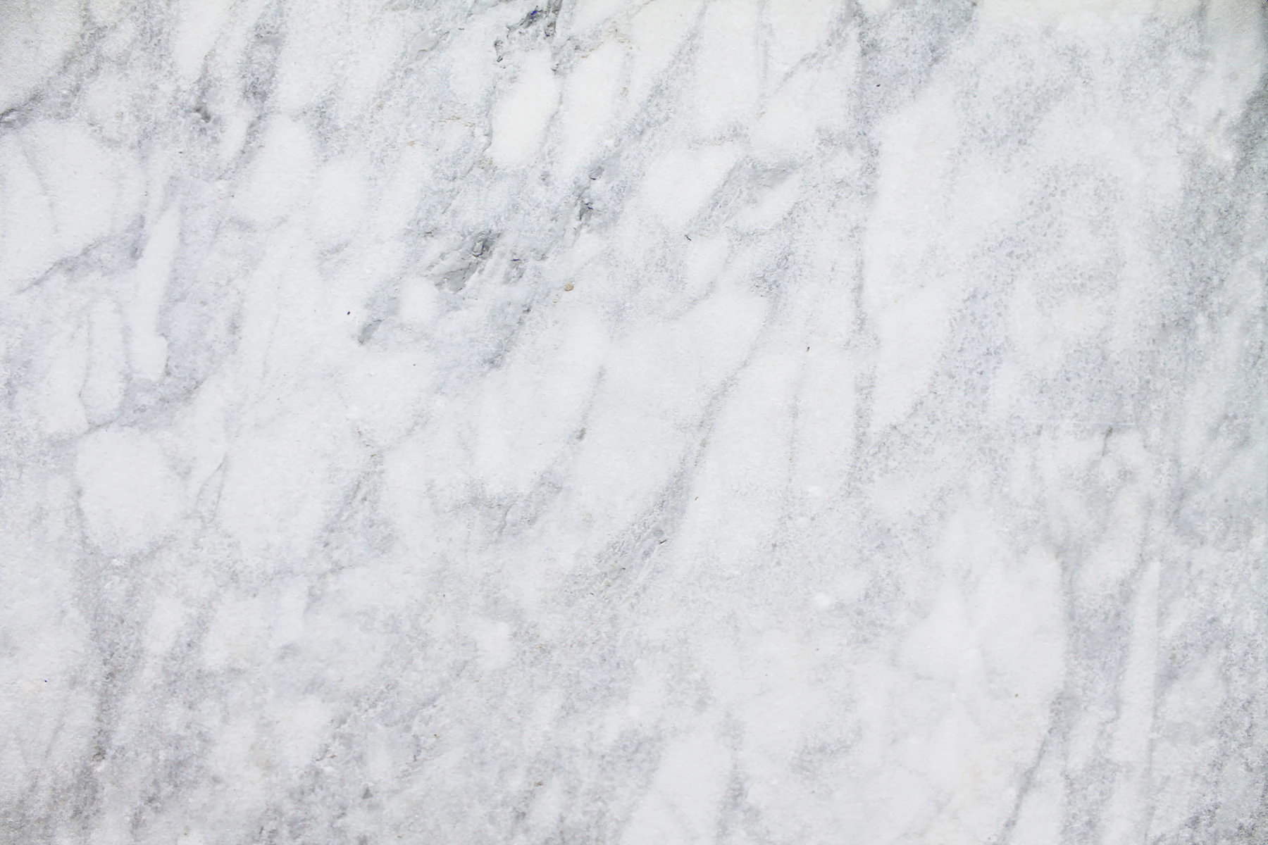 Close-up of a pale white stone or marble-like surface with soft grey veining.